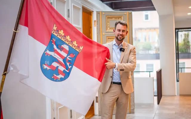 Maximilian Bathon vor der hessischen Landesflagge